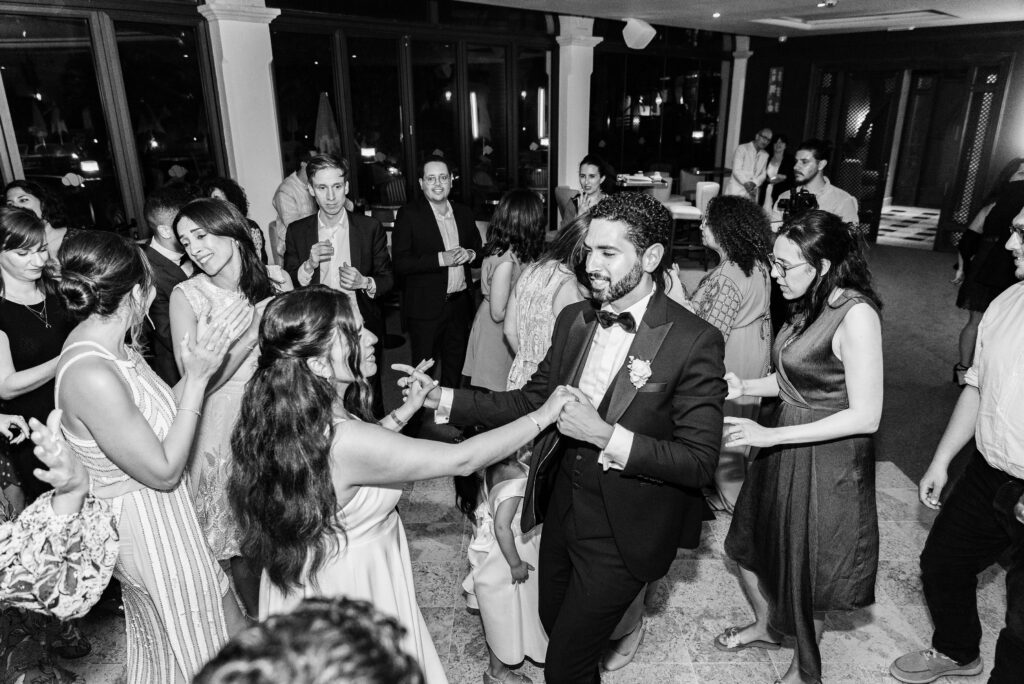 Animada recepción de boda en blanco y negro con invitados bailando. Fotografía por Emocionartestudio para BodasPro Wedding Planner