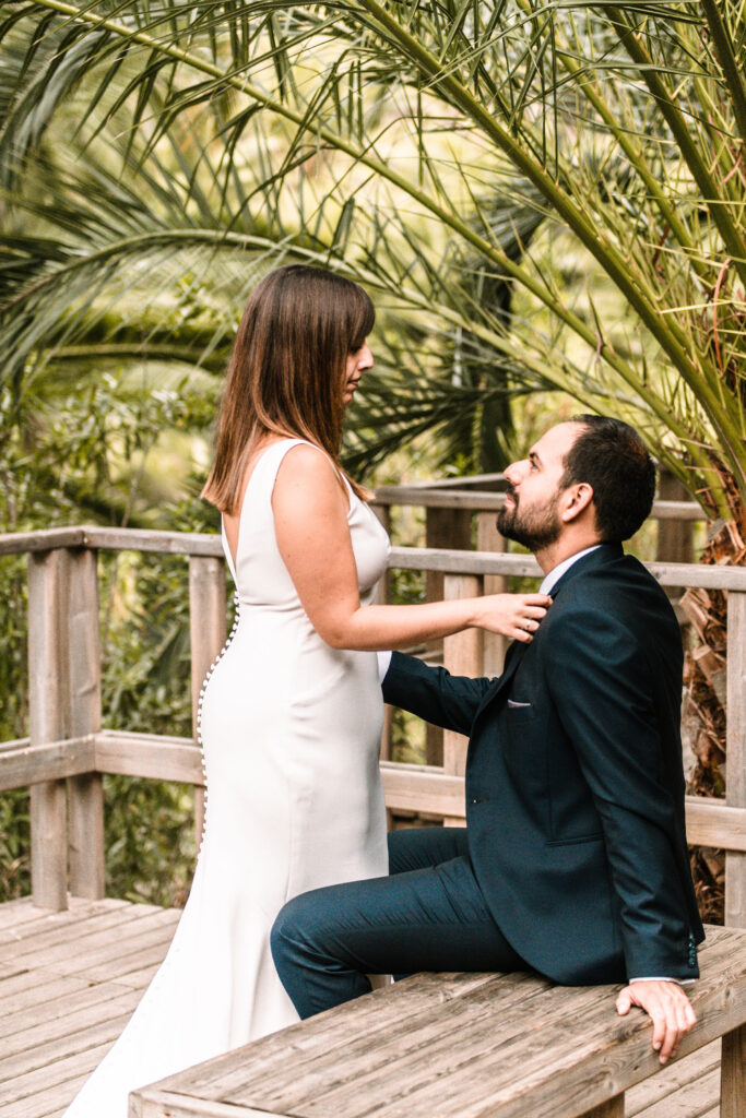 Esta imagen refleja las tendencias de bodas para 2025, incluyendo entornos naturales, vestidos de novia con detalles clásicos como botones y trajes formales oscuros para hombres