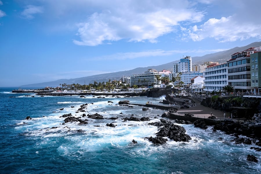 Fotos Tenerife: Un rincón de la costa de Tenerife con edificios turísticos y el mar en calma, capturado en esta imagen. ¡Explora la isla y descubre sus lugares más fotogénicos!