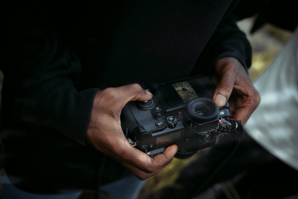 Detalle de una cámara réflex digital en manos de un fotógrafo, mostrando el equipo utilizado en fotografíal.