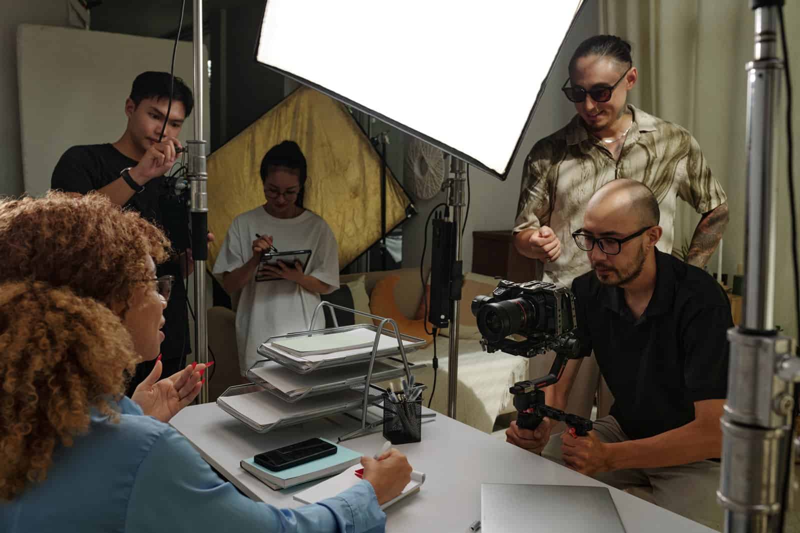 Equipo audiovisual grabando una entrevista en estudio: cámara hand-held, micro boom y dirección