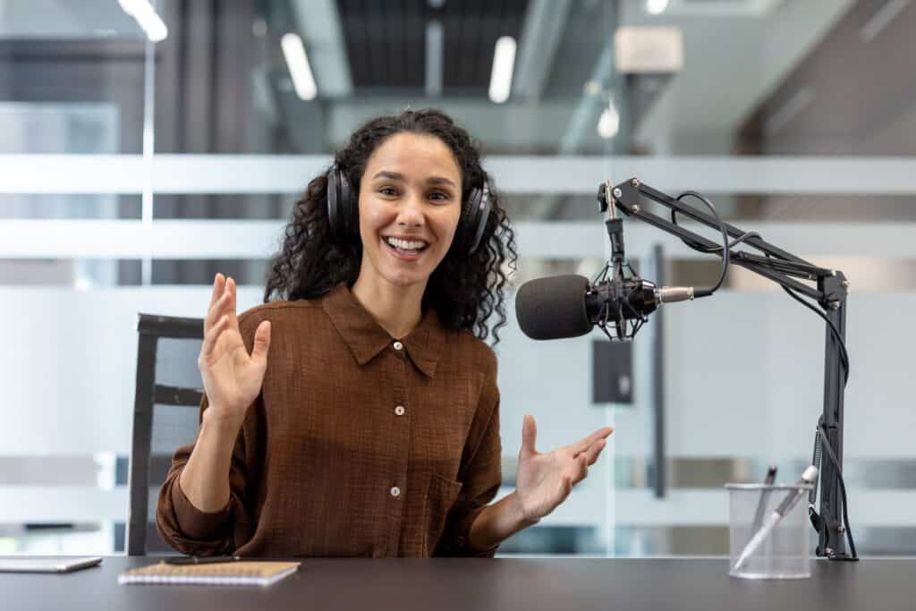 Presentadora grabando un podcast con micrófono broadcast en un estudio profesional moderno